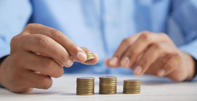 a person stacking coins on top of a table